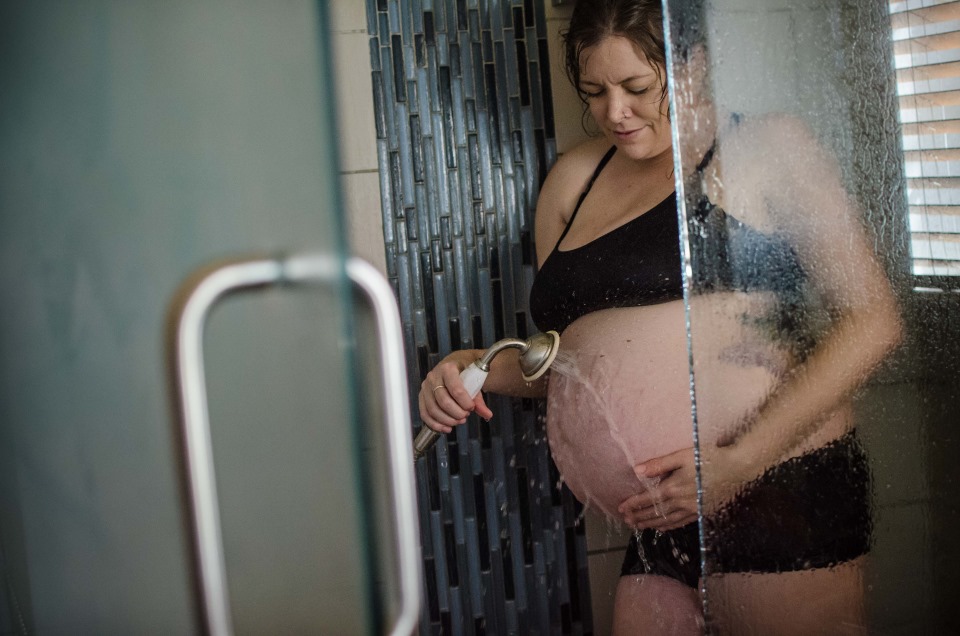 pregnant mom taking a shower at out Babymoon in Pheonix birthcenter